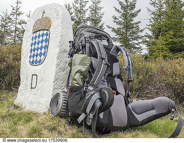 Backpack left beside stone border post in Bavarian Forest