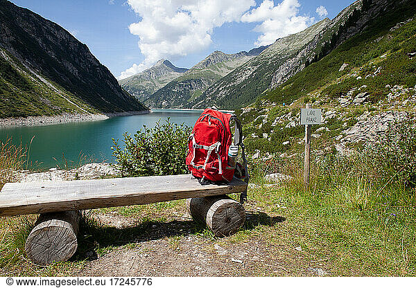 Backpack on wooden bench during sunny day at Zillertal  Austria