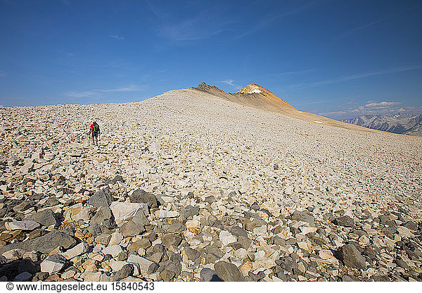 Backpacker crosses boulder field en route to Orchre Mountain.