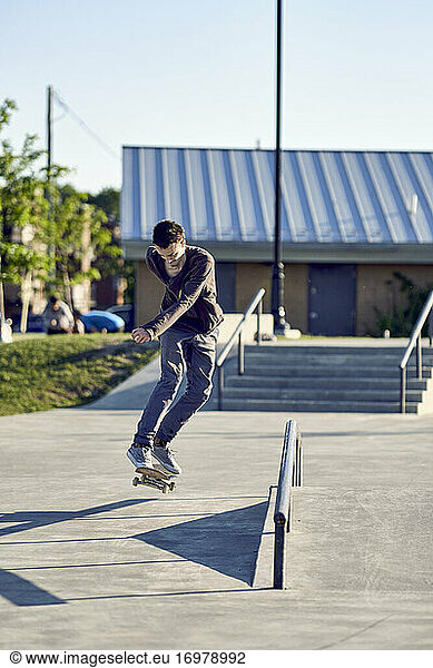 Backside flip over handrail in skatepark
