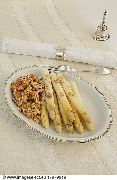 Baden cuisine  asparagus with crisp  flädle  pancakes made of potato dough torn into pieces with white asparagus  vegetables  healthy  hearty  from the pan  vegetarian  typically Baden  traditional cuisine  serving platter  napkin ring  napkin  table bell  fork  silverware  food photography  studio  Germany  Europe