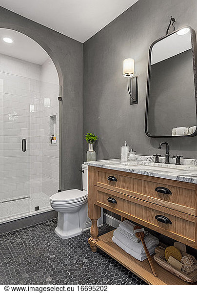 Badezimmer im Haus mit Dusche  Waschtisch  Spiegel  Waschbecken und Fliesenboden