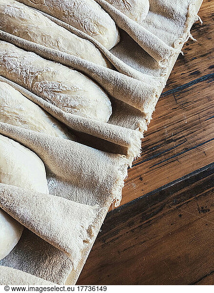 Baguette dough arranged on napkin for proofing