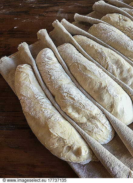 Baguette dough arranged on table at French bakery