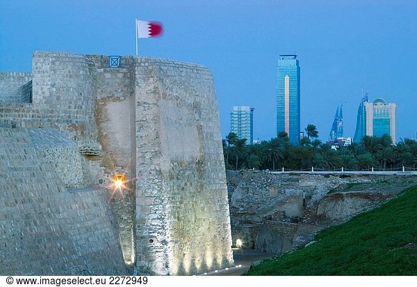 BAHRAIN-Manama: Bahrain Fort (b. Jahrhundert von den Portugiesen) Fort Äußeres und Manama Skyline / Abend
