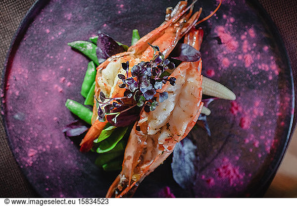 Baked tiger prawn with asparagus and micro greens for dinner at the re