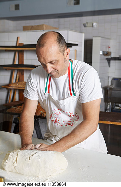 Baker in bakery  making bread