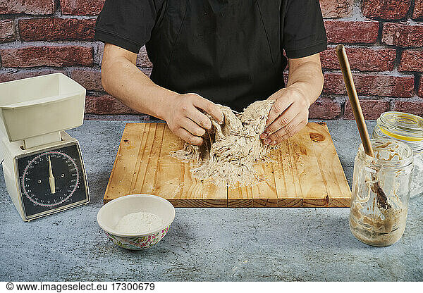 Baker kneading dough for the preparation of artisan bread