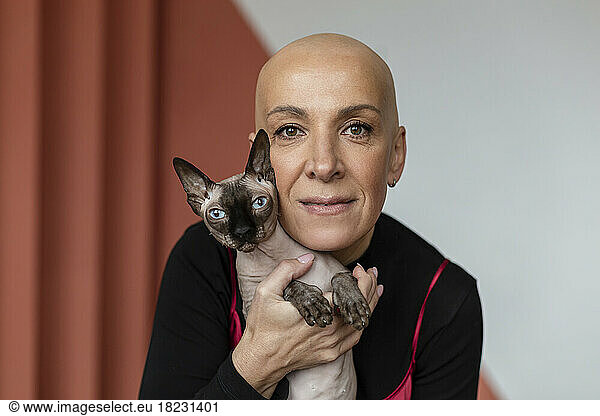 Bald woman embracing hairless Sphynx cat