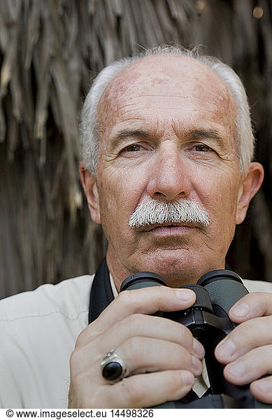 Balding Elderly Man With Moustache Holding Binoculars