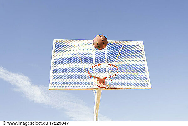 Ball über Basketballkorb an sonnigem Tag