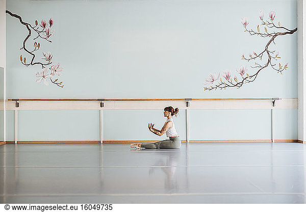 Ballerina exercising on floor in studio