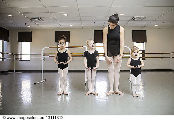 Ballerina teaching students in dance studio