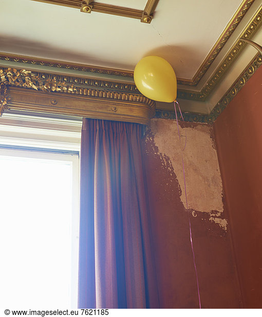 Balloon floating in corner of ornate room