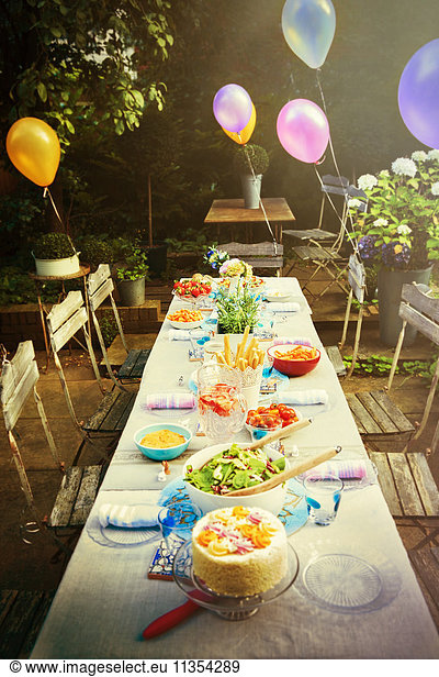 Balloons and food at garden party patio table