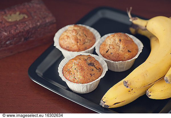 Banana muffins with walnut and chocolate slivers on plate