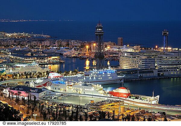 Barcelona  Spain  April 15  2019: Aerial view of Barcelona city skyline with city traffic and port with yachts and ferry ships illuminated in the night. Barcelona  Spain  Europe