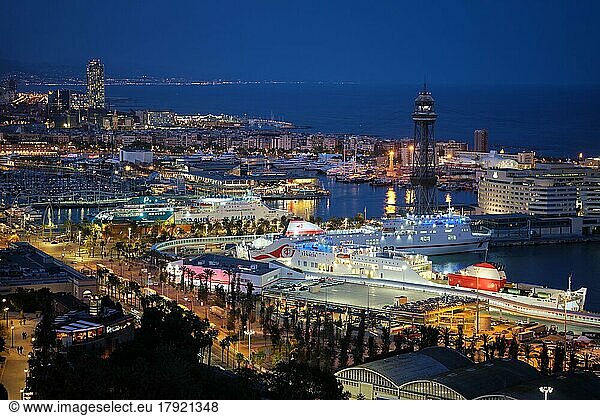 BARCELONA  SPAIN  APRIL 15  2019: Aerial view of Barcelona city skyline with city traffic and port with yachts and ferry ships illuminated in the night. Barcelona  Spain  Europe