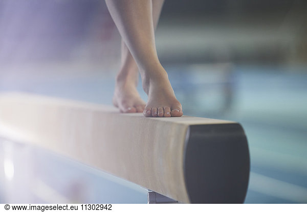 Bare feet of female gymnast performing on balance beam