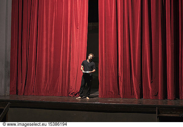 Barefoot actor with script standing on theatre stage Barefoot actor ...