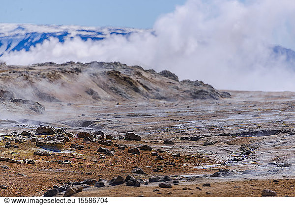 Barren landscape with steam rising beyond rocks  Akureyri  Eyjafjardarsysla  Iceland