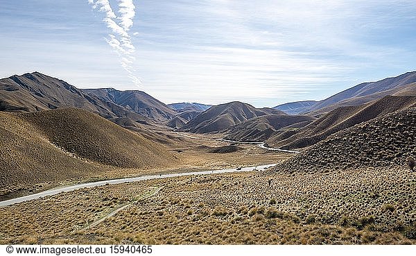Barren mountain landscape with tufts of grass  pass road  Lindis Pass  Southern Alps  Otago  South Island  New Zealand  Oceania