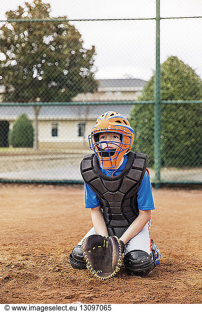 Baseball catcher kneeling on field