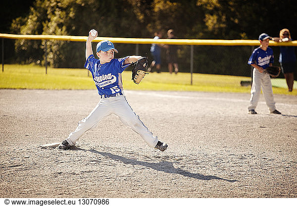 Baseball pitcher throwing ball while playing baseball