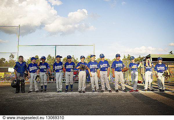 Baseball team standing on field against sky
