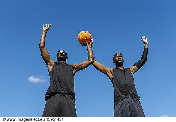 Basektballspieler mit erhobenen Armen und Ball