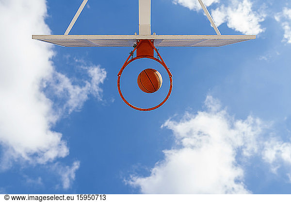 Basketball and hoop  blue sky  upward view