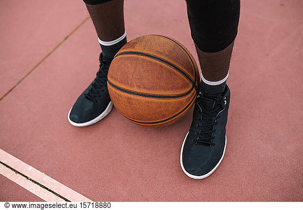 Basketball between feet of basketball player