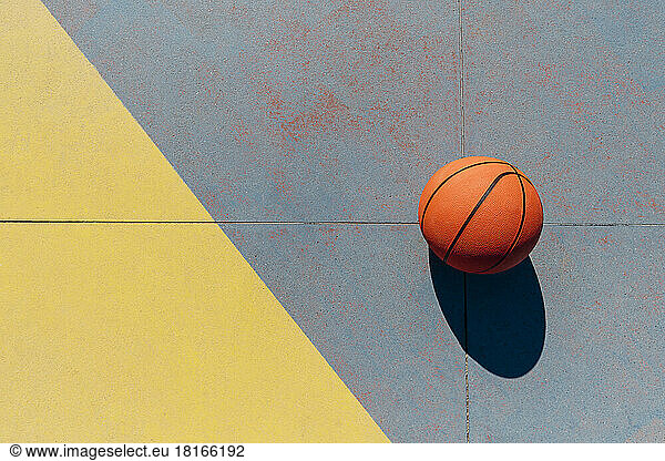 Basketball in sports court on sunny day