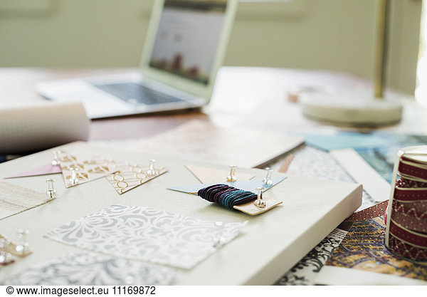 Bastelmaterial  Stoff und Papier  Muster sowie ein Notizbuch und eine Tafel.