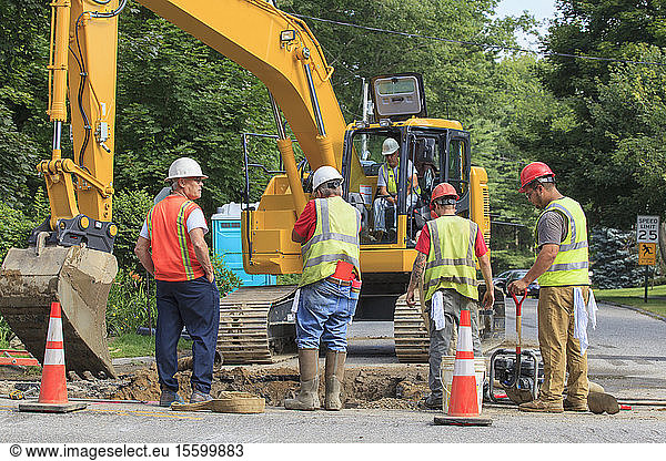 Bauarbeiter graben ein Loch  um die Wasserleitung zu ersetzen