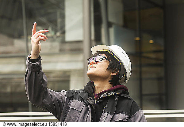 Bauingenieur mit Helm vor einem Gebäude