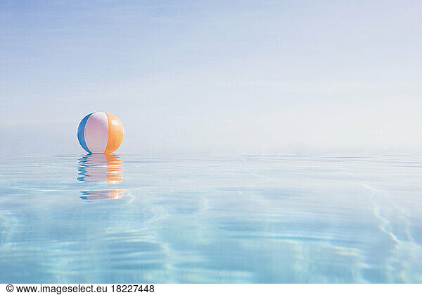 Beach ball floating on water surface