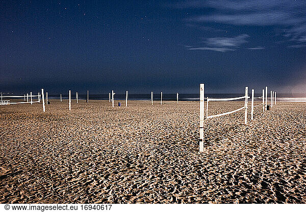 Beach volleyball nets on sand on beach.