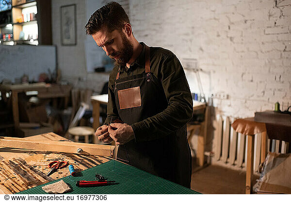 Bearded craftsman thinking over handicraft