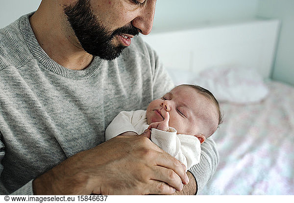 Bearded dad lovingly holds newborn with everyday disability