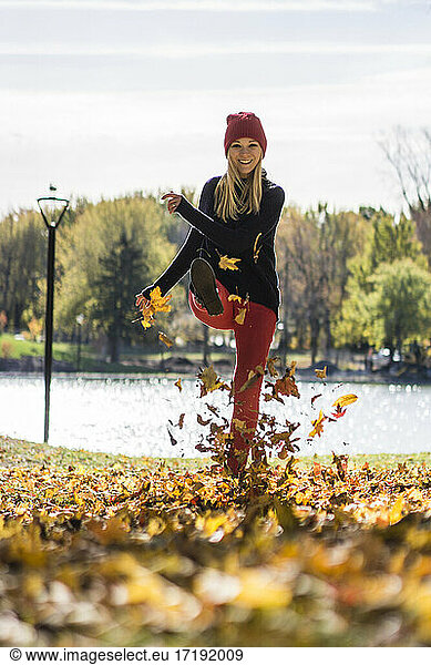 Beautiful blonde girl playing with leaves