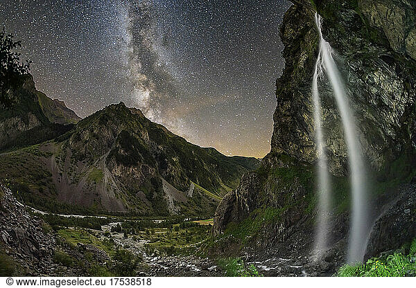 Beautiful Cascade du Casset waterfall from cliff at night with Milky Way in sky  Valgaudemar  Ecrins National Park. France