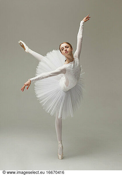 beautiful female ballet dancer in white ballet dress dancing tiptoe