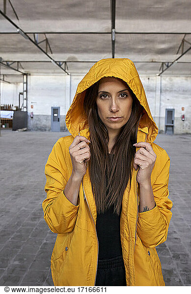 Beautiful female dancer in yellow jacket at abandoned factory