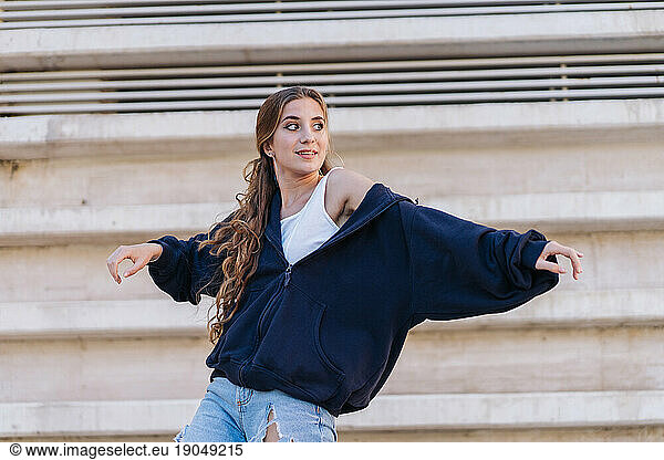 Beautiful Girl Dancing Next To A Concrete Wall.