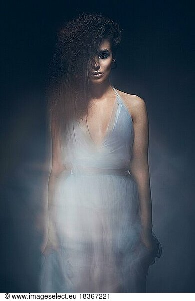 Beautiful girl in a light blue dress and long hair in a fashionable image. Beauty fashion style. Picture taken in the studio with mixed light