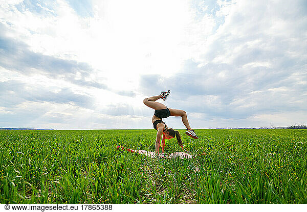 beautiful girl model on green grass do yoga
