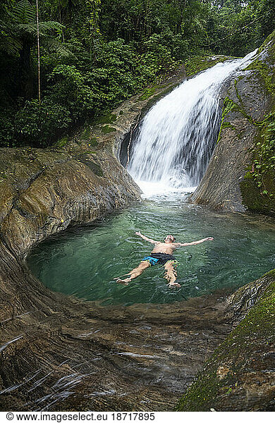 Beautiful landscape of man floating on crystal clear water river