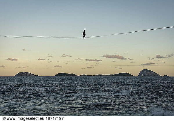 Beautiful landscape of man walking highline over ocean and islands