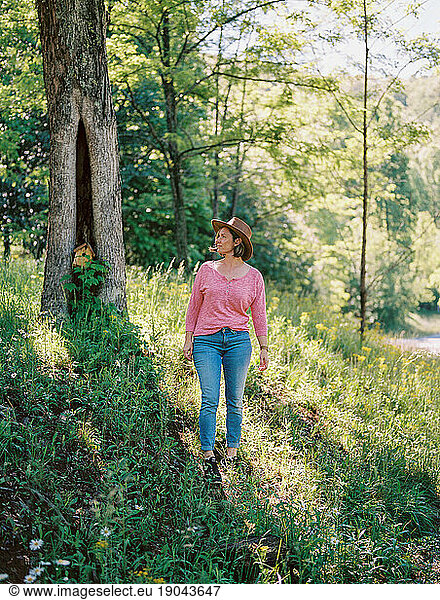 beautiful middle-aged woman walking through the woods of Ellijay  GA.